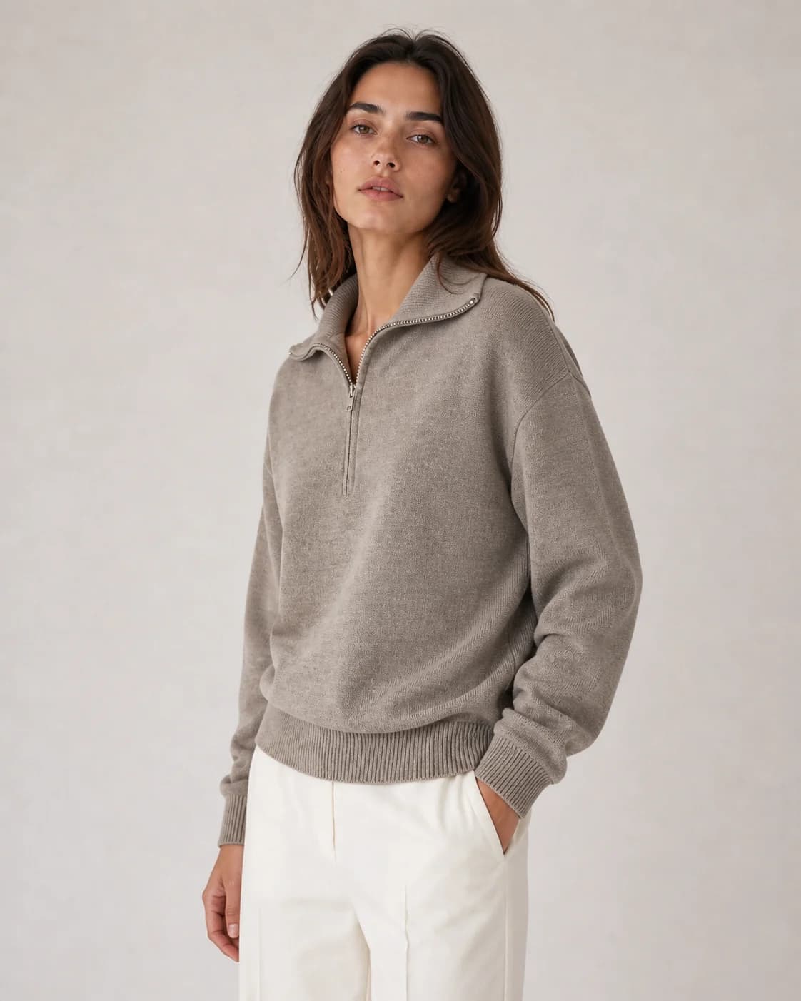 Closer view of a woman in the same grey half-zip pullover, with the collar and knit texture visible
